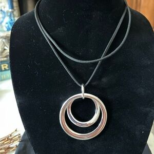 Silver pendant on black leather necklace